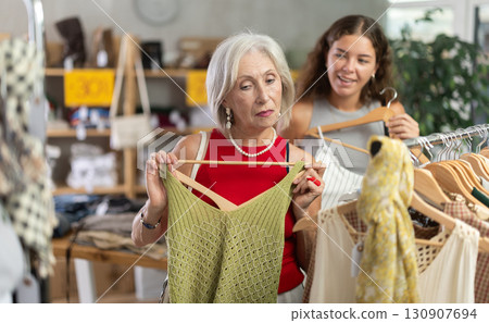 Elderly and young women choosing summer clothes in store 130907694