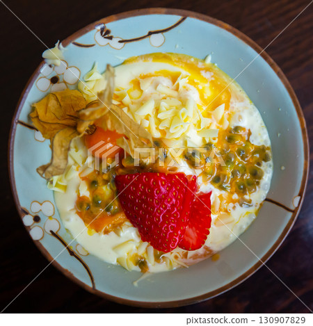 Delicate passion fruit mousse with yogurt, strawberry and physalis 130907829