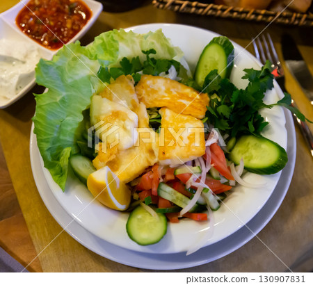 Salad with fried halloumi cheese with vegetables, greens, lemon Salad with fried halloumi cheese with vegetables, greens, lemon 130907831