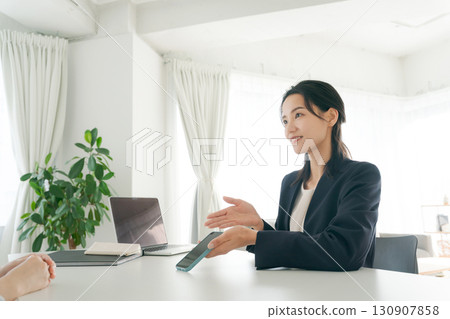 A businesswoman explaining a smartphone 130907858