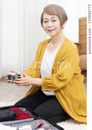 Senior woman packing for a trip 130908773