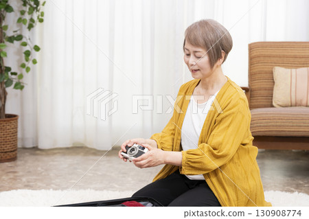Senior woman packing for a trip 130908774