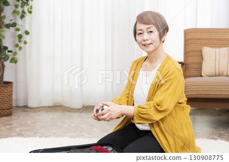 一位老年婦女打包行李準備旅行 130908775
