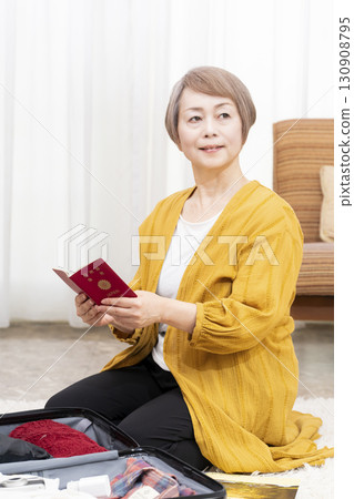 Senior woman packing for a trip 130908795