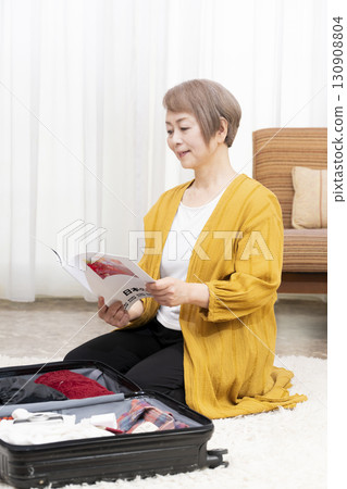 Senior woman packing for a trip 130908804