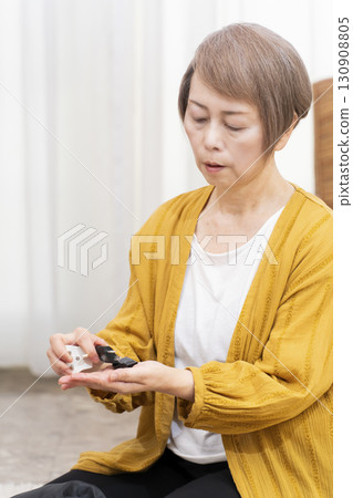 一位老年婦女打包行李準備旅行 一位老年婦女打包行李準備旅行 130908805