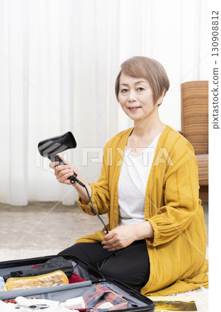 一位老年婦女打包行李準備旅行 130908812