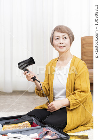 一位老年婦女打包行李準備旅行 一位老年婦女打包行李準備旅行 130908813