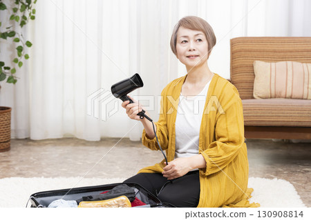 一位老年婦女打包行李準備旅行 130908814