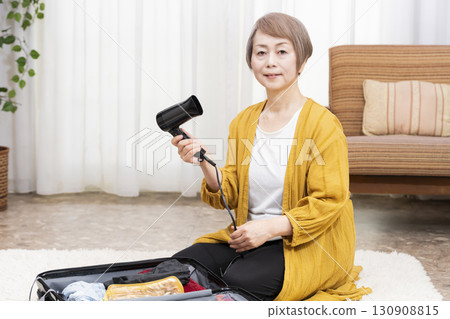 Senior woman packing for a trip 130908815