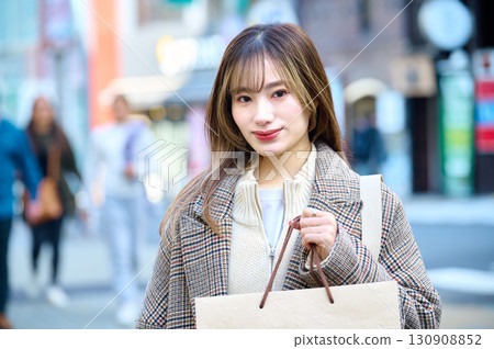 穿著冬衣、提著購物袋的女人 130908852