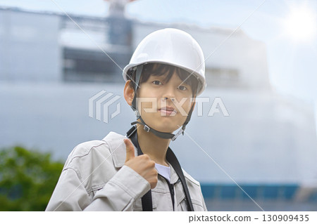 Young businessman in work clothes looking at a tablet at a construction site Young businessman in work clothes looking at a tablet at a construction site 130909435