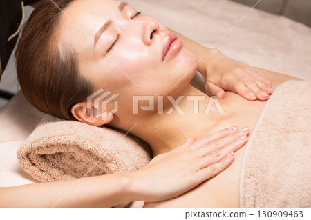 A young Asian woman is getting a decollete massage. A young Asian woman is getting a decollete massage. 130909463
