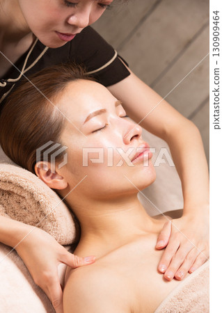 一位年輕的亞洲女性正在接受肩部按摩。 一位年輕的亞洲女性正在接受肩部按摩。 130909464