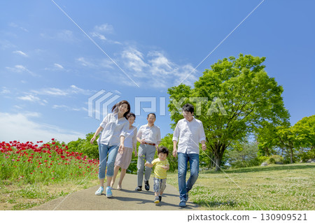 一個三代家庭走過開滿罌粟花的公園 130909521