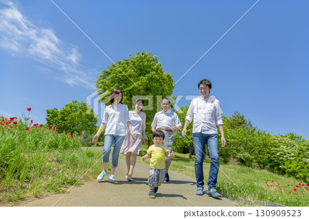 一個三代家庭走過開滿罌粟花的公園 130909523