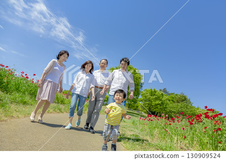 一個三代家庭走過開滿罌粟花的公園 一個三代家庭走過開滿罌粟花的公園 130909524