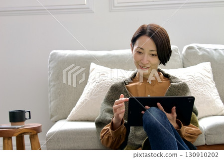 Woman operating a tablet 130910202