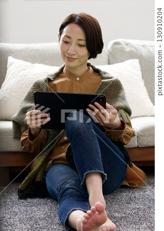 Woman operating a tablet 130910204