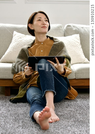 Woman operating a tablet Woman operating a tablet 130910215