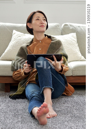 Woman operating a tablet 130910219