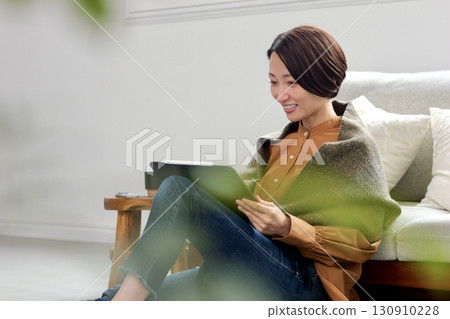 Woman operating a tablet Woman operating a tablet 130910228