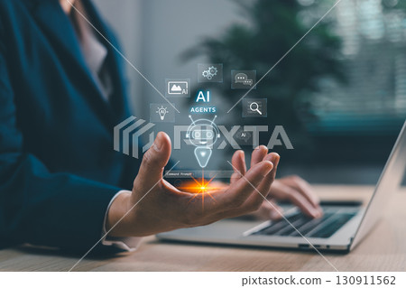 Businessman using laptop with AI agents holographic robot assistant. Artificial intelligence for chatbots, automation, data analytics and digital transformation in smart business solutions. 130911562