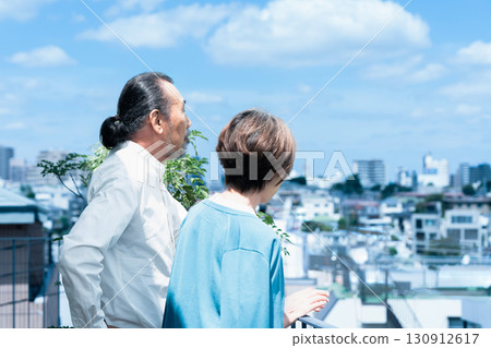 Senior couple watching the city from the terrace Senior couple watching the city from the terrace 130912617