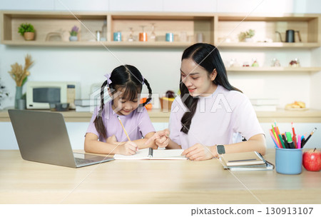 Back to School. Mother helping daughter with homework at kitchen table. 130913107