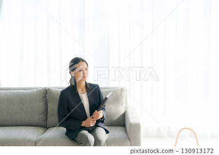 A woman operating a smartphone on the sofa in the living room 130913172