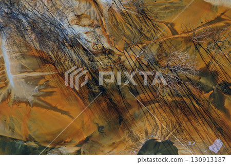 Aerial view of acid mine water drainage flow, toxic mine waters polluting the environment. Rosia Montana, Romania Aerial view of acid mine water drainage flow, toxic mine waters polluting the environment. Rosia Montana, Romania 130913187