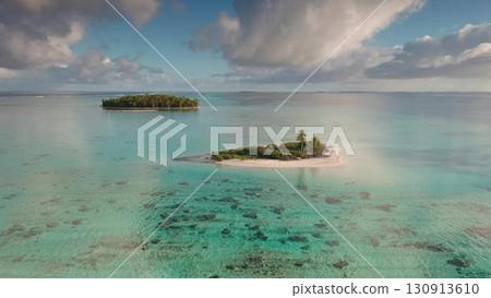 Small tropical islands in French Polynesia archipelago. Turquoise coral reef lagoon, palm trees and sunset blue sky. Beautiful landscape of untouched nature. Remote wild nature exotic summer travel Small tropical islands in French Polynesia archipelago. Turquoise coral reef lagoon, palm trees and sunset blue sky. Beautiful landscape of untouched nature. Remote wild nature exotic summer travel 130913610