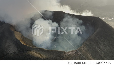 Fiji, Tana Island: dramatic landscape of Port Resolution on Tana Island, featuring an active volcano smoking crater amid rugged terrain. Wild nature travel landscape. Drone aerial view flight 130913629
