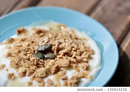 Granola yogurt with honey on a flat plate Granola yogurt with honey on a flat plate 130914238