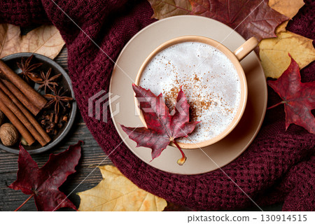 Autumn latte coffee with maple leaf and cozy plaid 130914515