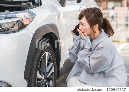 一名女駕駛在發生車禍後用智慧型手機撥打電話（道路服務） 130914837