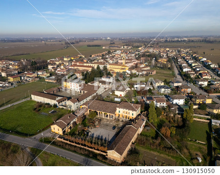 Stagno Lombardo, Italy, featuring residential homes and cultivated farmland in aerial view 130915050