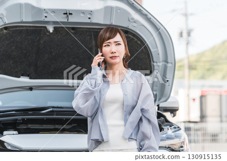亞洲女性在汽車前用智慧型手機打電話（道路服務、麻煩、救援、麻煩） 130915135
