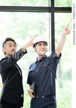 A man in profile wearing work clothes and a helmet by a window with fresh greenery, two men in suits, and a woman checking the safety of maintenance work on buildings, etc. 130915327