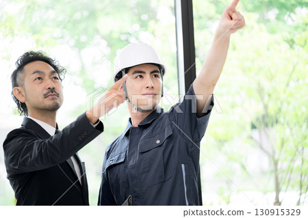A man in profile wearing work clothes and a helmet by a window with fresh greenery, two men in suits, and a woman checking the safety of maintenance work on buildings, etc. A man in profile wearing work clothes and a helmet by a window with fresh greenery, two men in suits, and a woman checking the safety of maintenance work on buildings, etc. 130915329