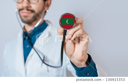 Doctor holding stethoscope with Maldives flag. Maldives health and care concept, Maldives flag on stethoscope 130915353