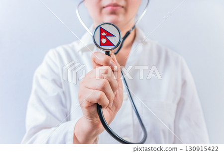 Female doctor holding stethoscope with Nepal flag. National health system of Nepal Female doctor holding stethoscope with Nepal flag. National health system of Nepal 130915422