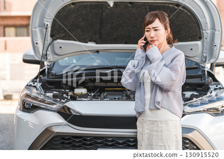 Asian woman calling on smartphone in front of car (road service, trouble, rescue, trouble) 130915520