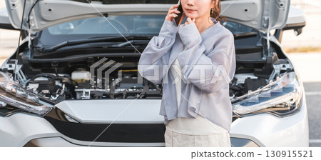 Asian woman calling on smartphone in front of car (road service, trouble, rescue, trouble) 130915521