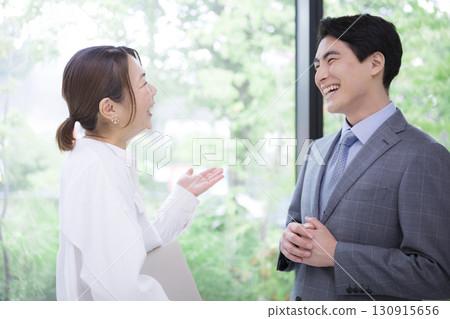綠意盎然的窗邊，女上司與男下屬的商務對話場景 130915656