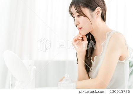 Asian woman looking in the mirror and feeling embarrassed (beauty, skin care, cosmetics, skin, anti-aging) 130915726