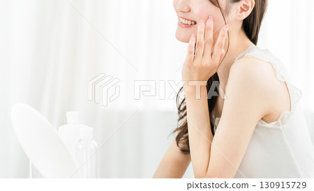 Asian woman looking in the mirror and doing skin care (moisturizing, beauty, cosmetics, skin, anti-aging) Asian woman looking in the mirror and doing skin care (moisturizing, beauty, cosmetics, skin, anti-aging) 130915729
