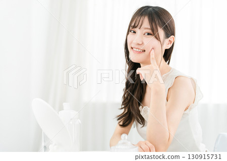 Asian woman looking in the mirror and doing skin care (moisturizing, beauty, cosmetics, skin, anti-aging) Asian woman looking in the mirror and doing skin care (moisturizing, beauty, cosmetics, skin, anti-aging) 130915731