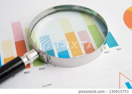 Magnifying glass on data business graphs paper. 130915751