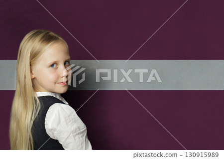Cute young child girl standing against flag of Latvia background. Education Latvian language concept Cute young child girl standing against flag of Latvia background. Education Latvian language concept 130915989